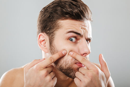 man squeezing blemish