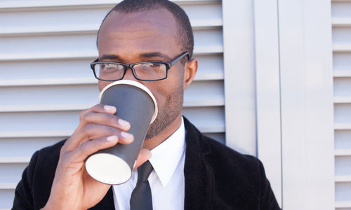 man drinking coffee outside office