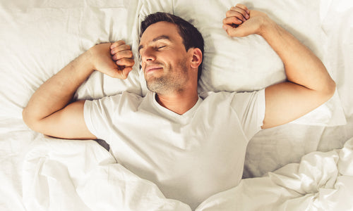 man stretching in bed